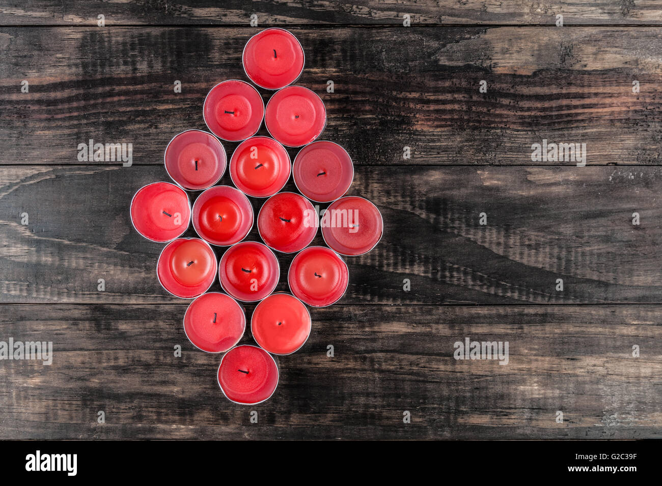 De nombreuses petites bougies rouge éteint makig une forme de diamant sur la table en bois Vue supérieure avec copie espace Banque D'Images