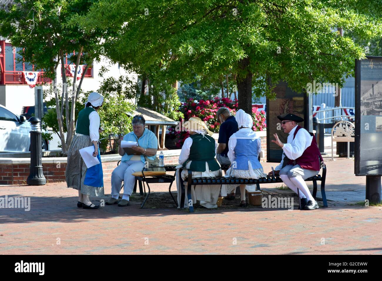 Un groupe d'Amish assis sur un banc de parc Banque D'Images