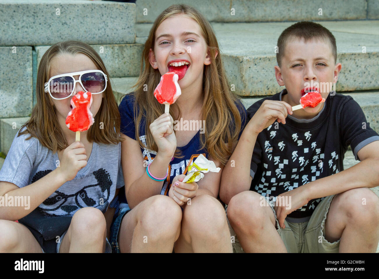 Trois enfants de manger de la crème glacée sur les étapes Banque D'Images