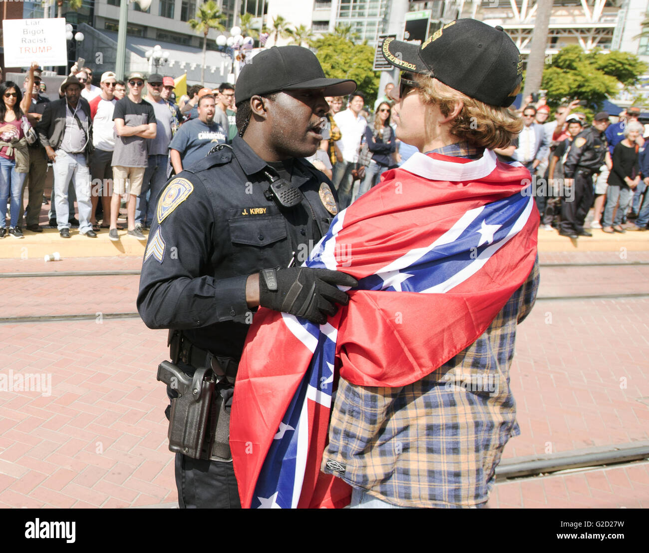 San Diego, Californie, USA. 27 mai, 2016. Un officier de police de San Diego affronte un homme portant un drapeau confédéré sur ses épaules à la suite d'une bagarre à coups de poing entre manifestants et partisans d'atout en avant du centre de congrès de San Diego, le vendredi après-midi. ---L'atout de Donald a fait campagne à San Diego au San Diego Convention Center le vendredi dimensions plusieurs milliers de partisans et des manifestants. Le Département de Police de San Diego a désigné deux zones pour la liberté de parole et les partisans d'atout des manifestants. Le rallye s'est terminé dans le calme bien qu'en tant que partisans d'atout et les manifestants se sont réunis sur le Banque D'Images