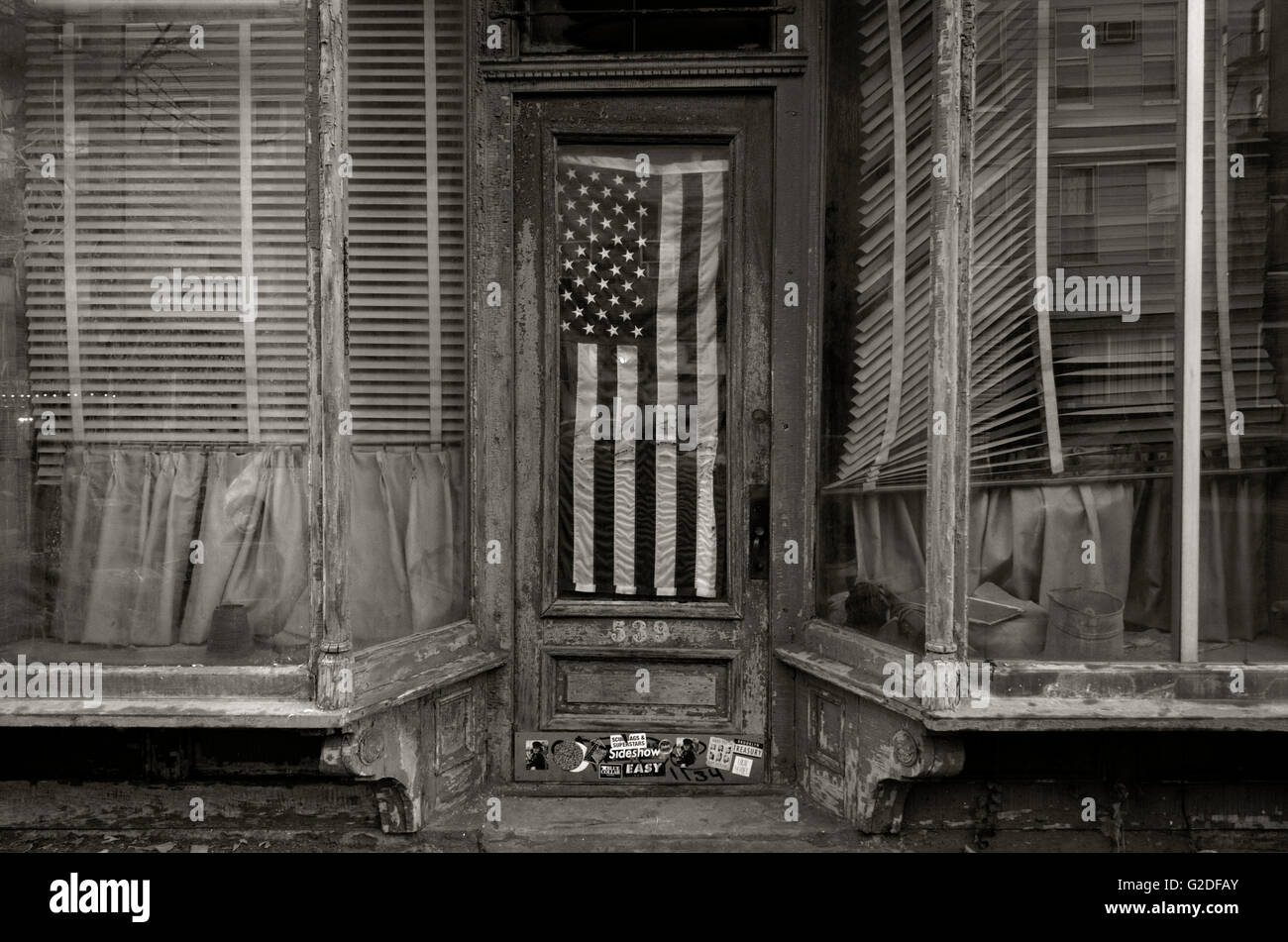 Devanture défraîchie avec drapeau américain suspendu dans la fenêtre de porte, Brooklyn, New York, USA Banque D'Images