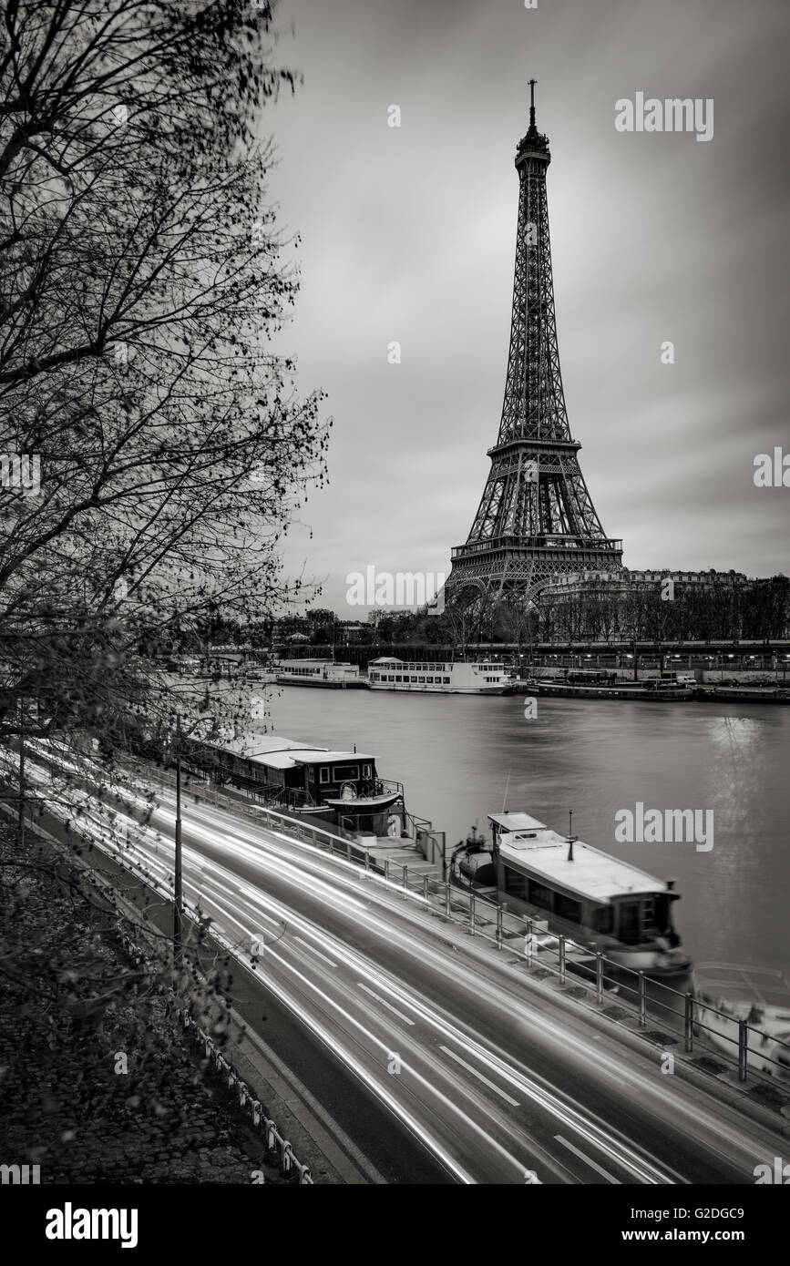 La Tour Eiffel et de la Seine River tôt le matin avec des nuages et des sentiers de lumière de voiture en noir et blanc. Paris, France Banque D'Images