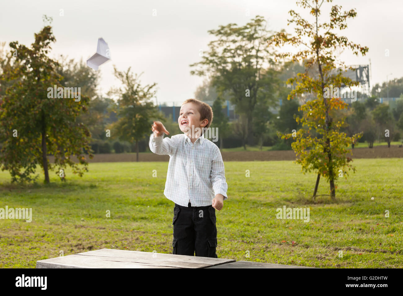 Enfant jouant avec un avion en papier Banque D'Images