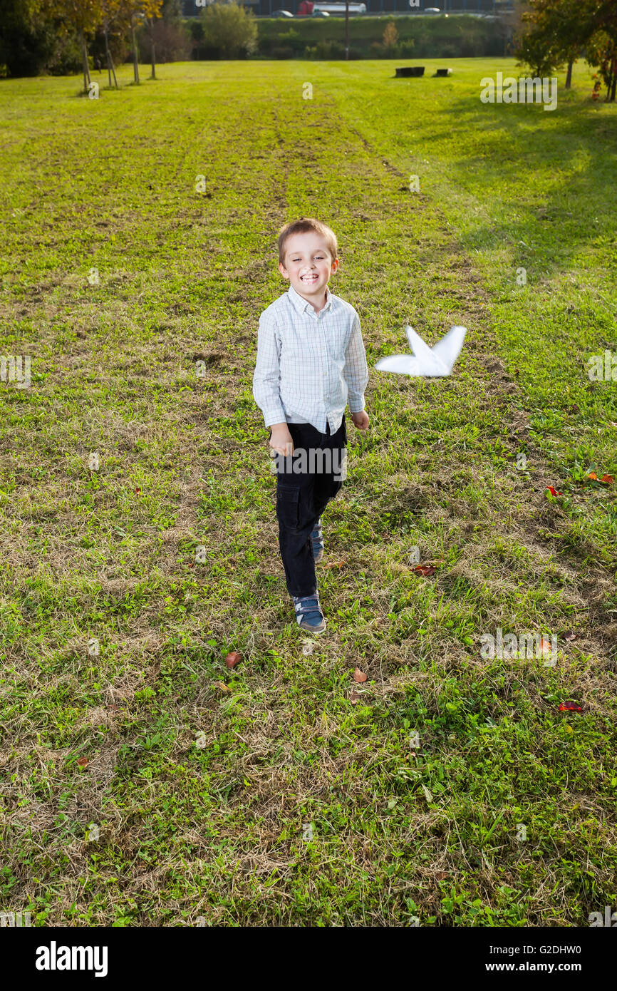 Enfant jouant de lancer un avion en papier Banque D'Images