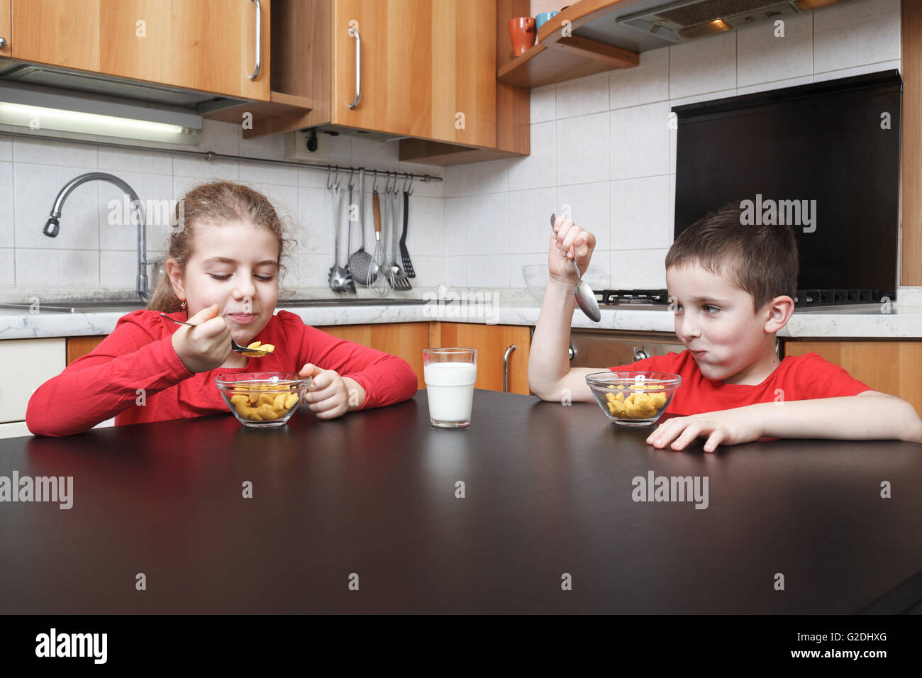 Les enfants dans la cuisine des céréales de l'alimentation Banque D'Images