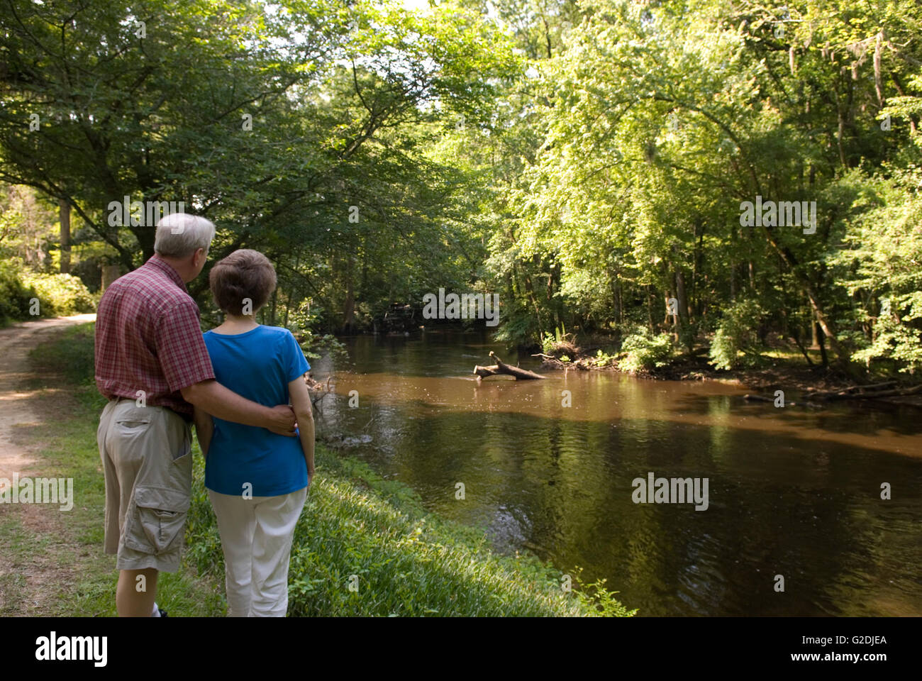 Homme caucasien avec bras autour de la femme profitant du paysage paisible à Edisto Memorial Gardens à Orangeburg, Caroline du Sud, États-Unis. Banque D'Images
