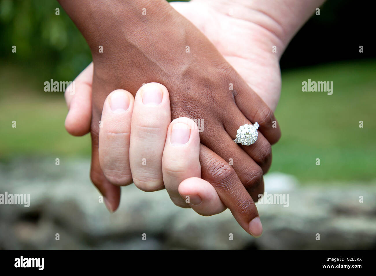 L'Interracial Couple Holding Hands and Diamond Engagement Ring, Close-Up Banque D'Images