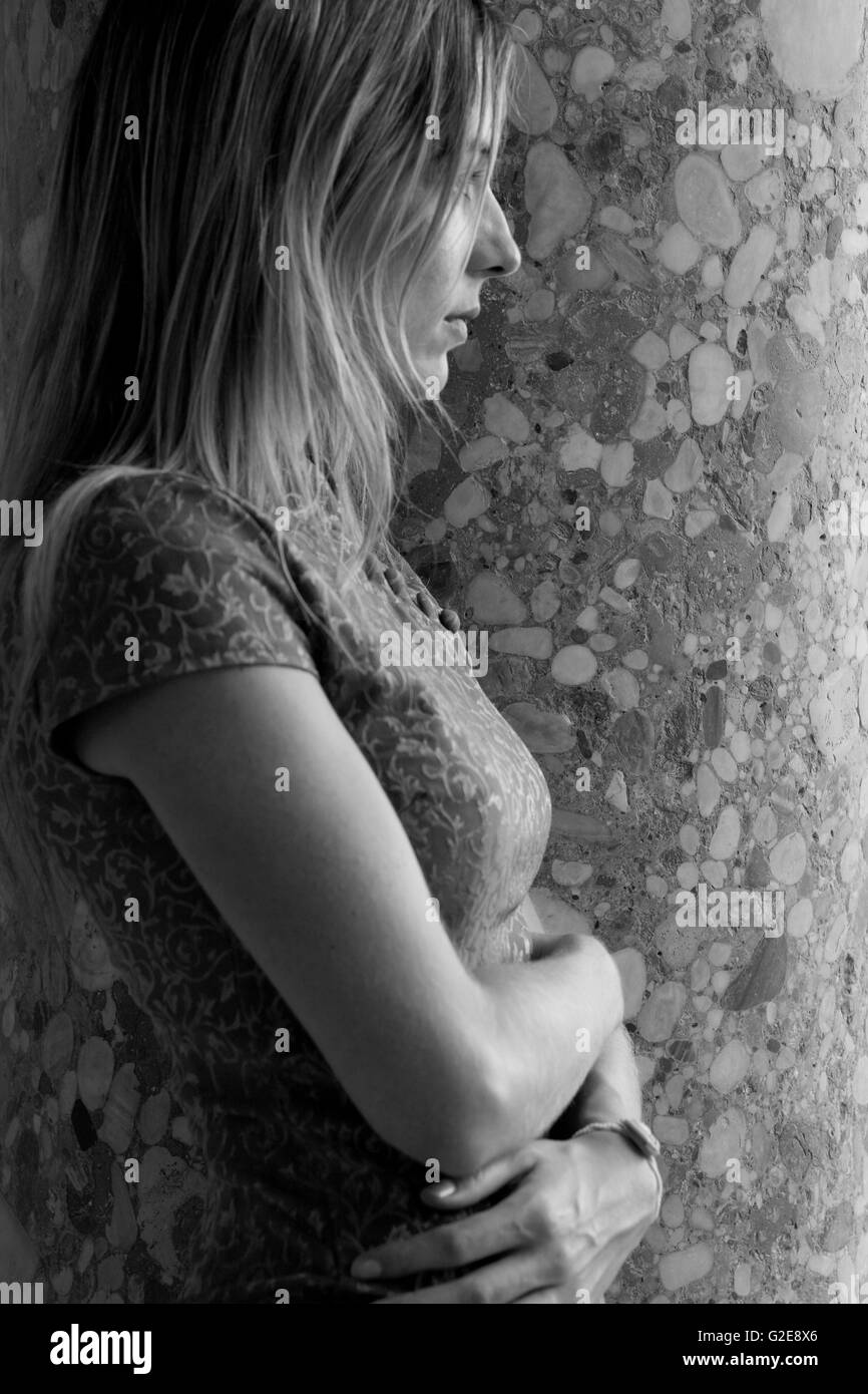 Femme contemplative contre mur, Waist-Up profil, Banque D'Images