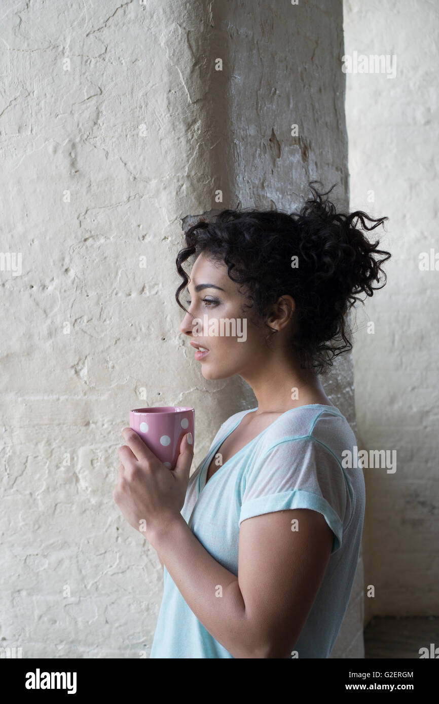 Worried woman drinking coffee à loin inquiet Banque D'Images