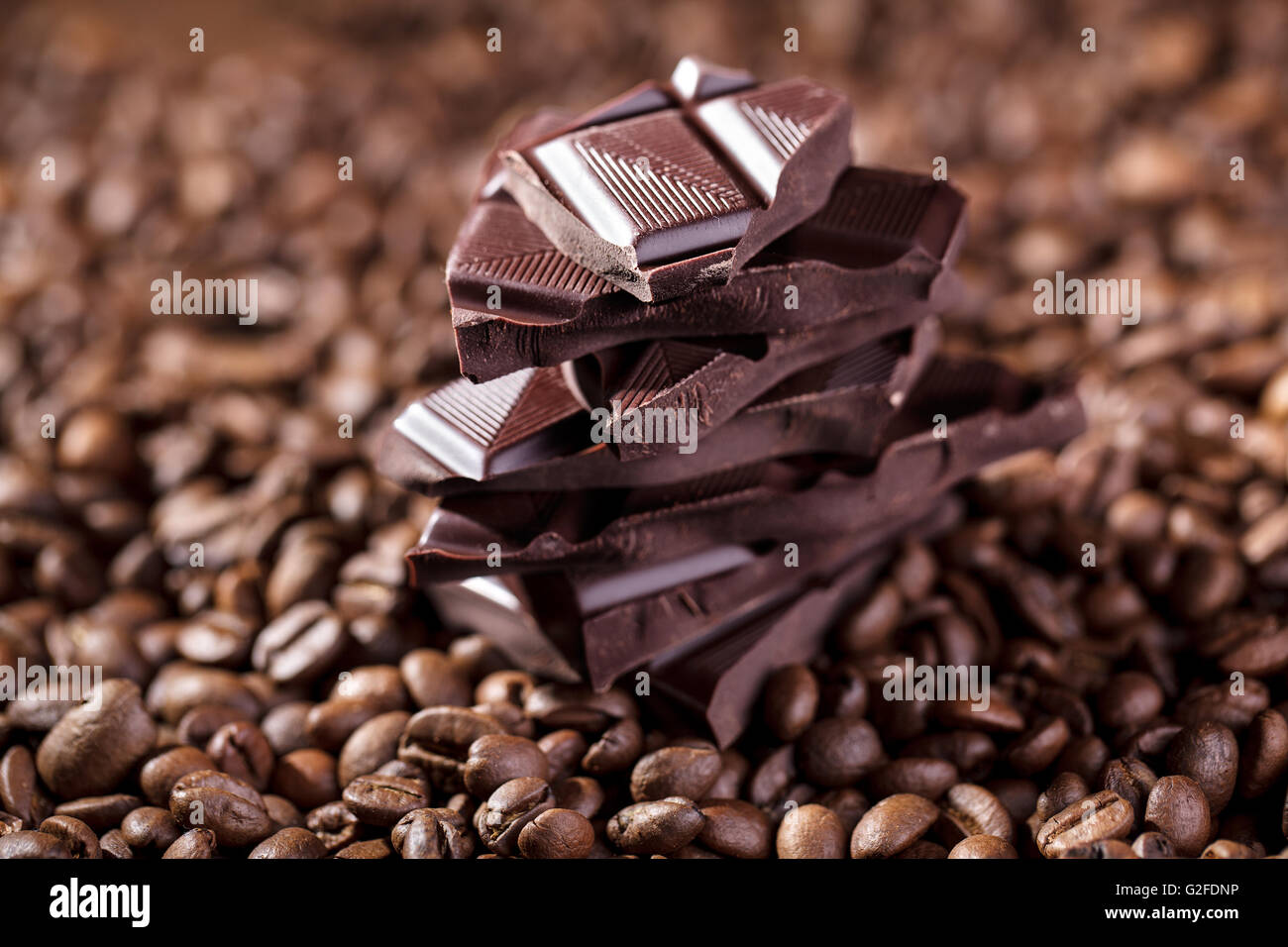 Des grains de café torréfiés et pile de chocolat Banque D'Images