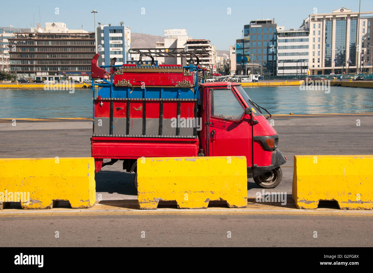 Petite voiture rouge et jaune le béton au Port du Pirée à Athènes, Grèce. Banque D'Images