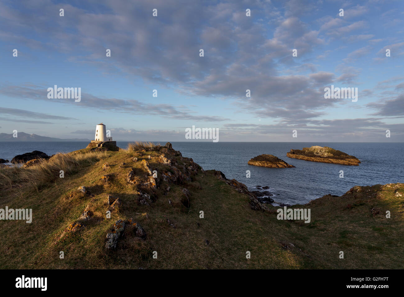 Tŵr Mawr phare sur l'île Llanddwyn, Anglesey, au nord du Pays de Galles UK au lever du soleil. Banque D'Images