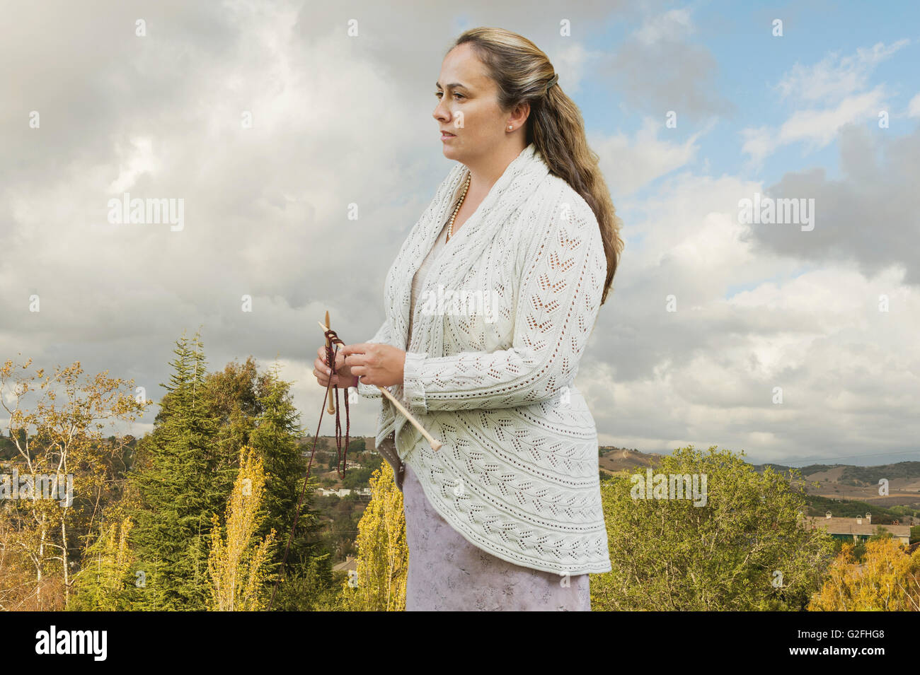 Portrait of Mid adult Woman Holding- Aiguilles à Tricoter Banque D'Images