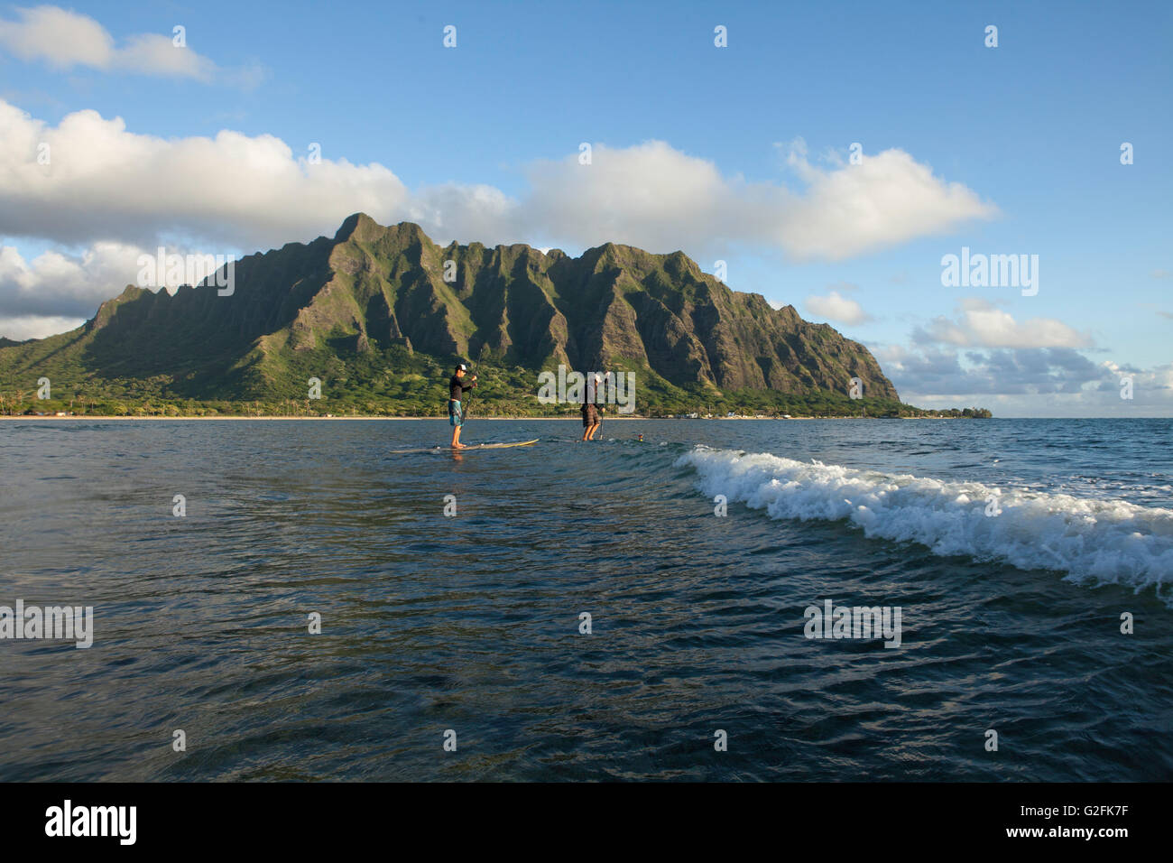 Montez le paddle-board dans la baie de Kaneohe, près de Kualoa et de l'île Mokoli'i (anciennement connu sous le nom de « chapeau de Chinaman »). Montagnes Koolau en vue. Banque D'Images