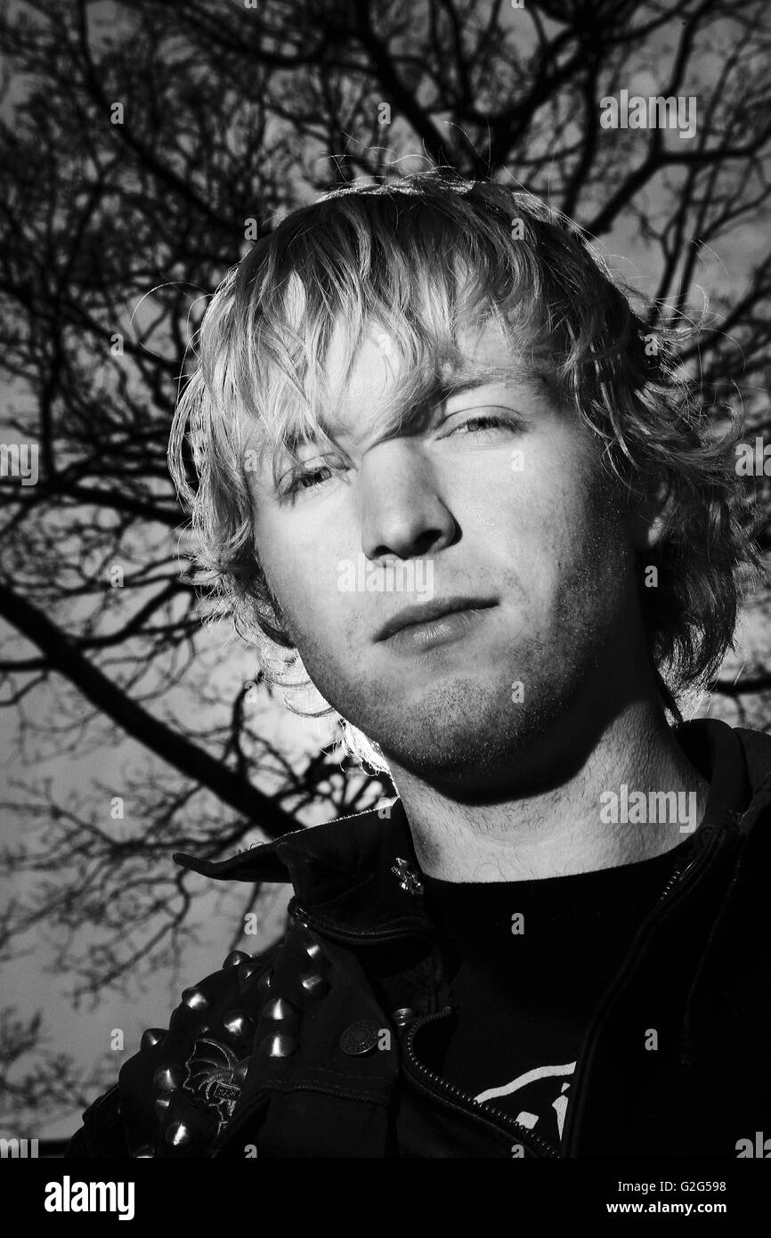 Jeune homme blond foncé contre Portrait de branches, Low Angle View, Portrait Banque D'Images