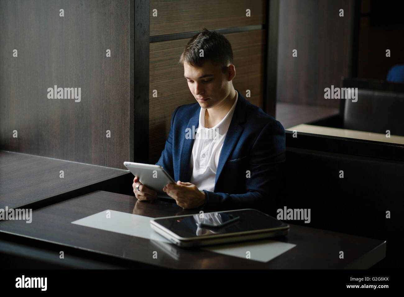 Portrait d'un jeune homme d'avoir vu sur son tablet pc dans le café. Banque D'Images