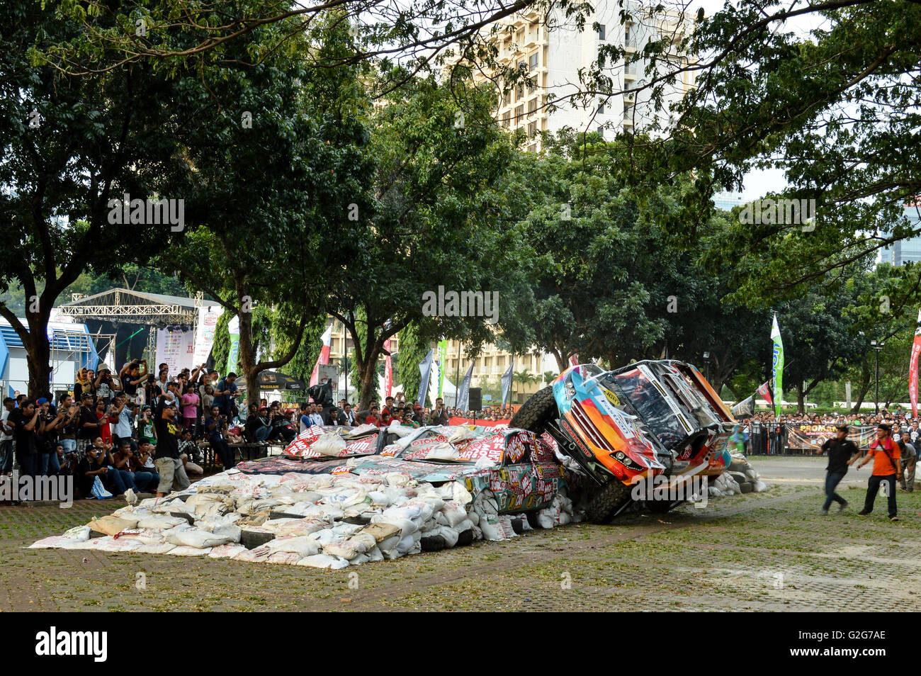 Les gens prendre des photos lorsque le patinage à côté de gajah monster voiture dans tumplek événement automobile blek, Jakarta, Indonésie Banque D'Images