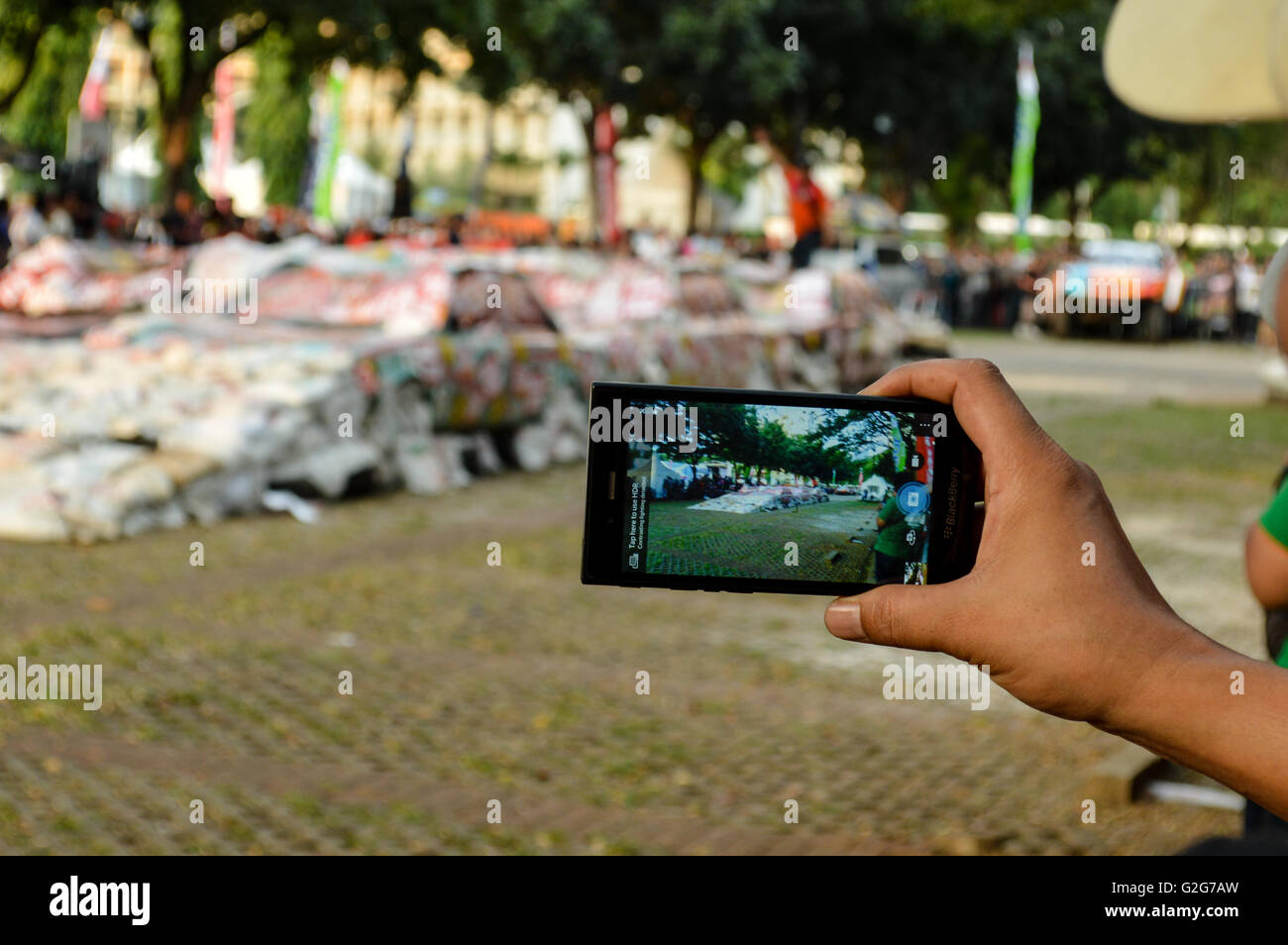 Les gens prendre des photos lorsque le patinage à côté de gajah monster voiture dans tumplek événement automobile blek, Jakarta, Indonésie Banque D'Images