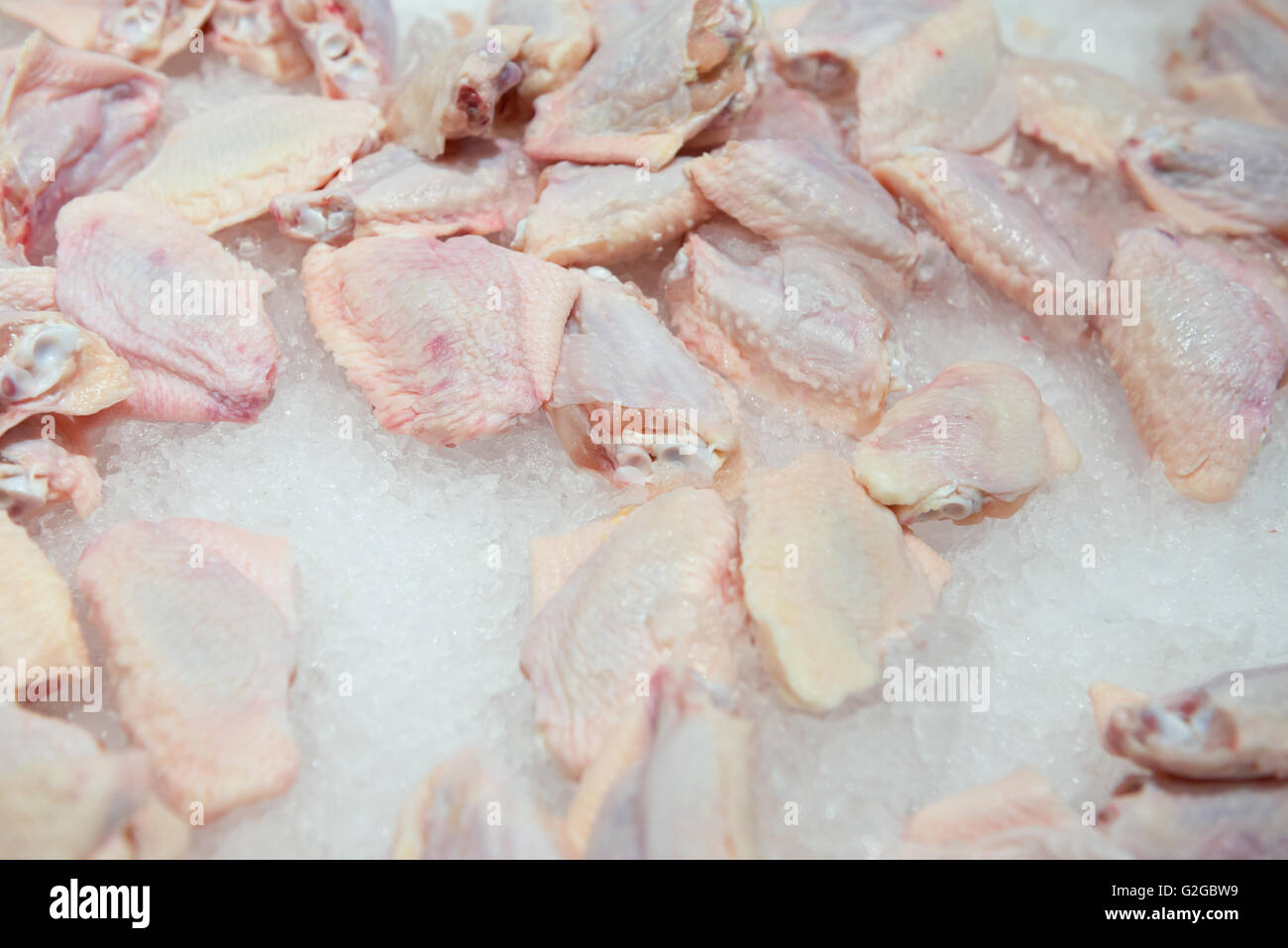 Ailes de poulet crues sur le dessus de la glace sur la vente au surpermarket Banque D'Images