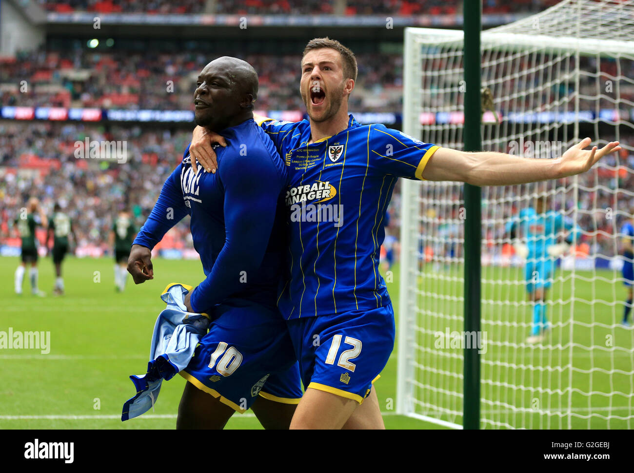L'AFC Wimbledon's Adebayo Akinfenwa (à gauche) célèbre avec coéquipier John Meades après avoir marqué son deuxième but du côté du point de penalty au cours de la Sky Bet League Deux Play-Off finale au stade de Wembley, Londres. Banque D'Images