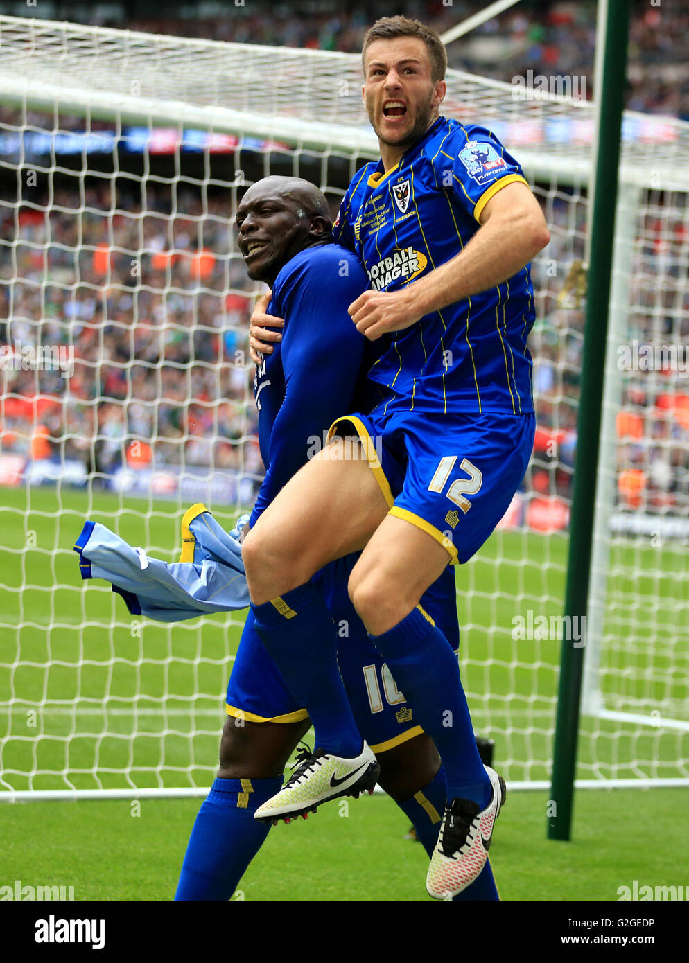 L'AFC Wimbledon's Adebayo Akinfenwa (à gauche) célèbre avec coéquipier John Meades après avoir marqué son deuxième but du côté du point de penalty au cours de la Sky Bet League Deux Play-Off finale au stade de Wembley, Londres. Banque D'Images