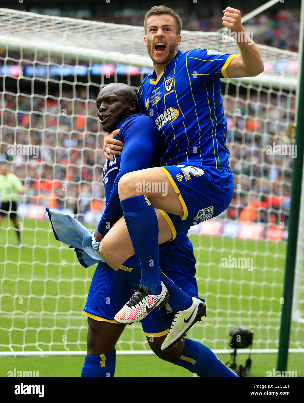 L'AFC Wimbledon's Adebayo Akinfenwa (à gauche) célèbre avec coéquipier John Meades après avoir marqué son deuxième but du côté du point de penalty au cours de la Sky Bet League Deux Play-Off finale au stade de Wembley, Londres. Banque D'Images