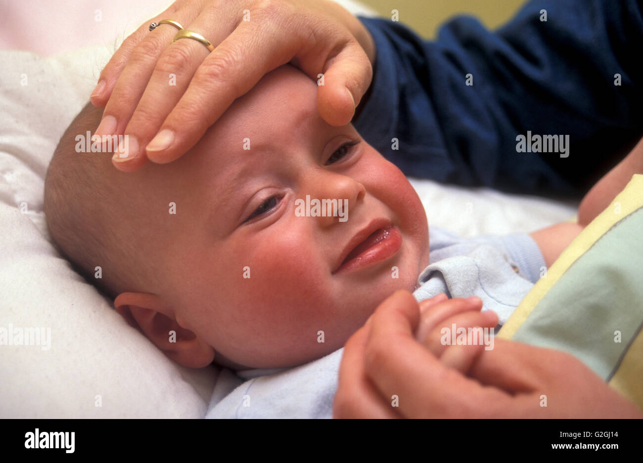 Mother holding baby avec fièvre Banque D'Images