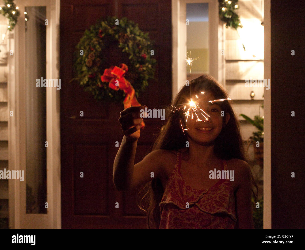 Girl with sparkler la nuit en face de la maison Banque D'Images