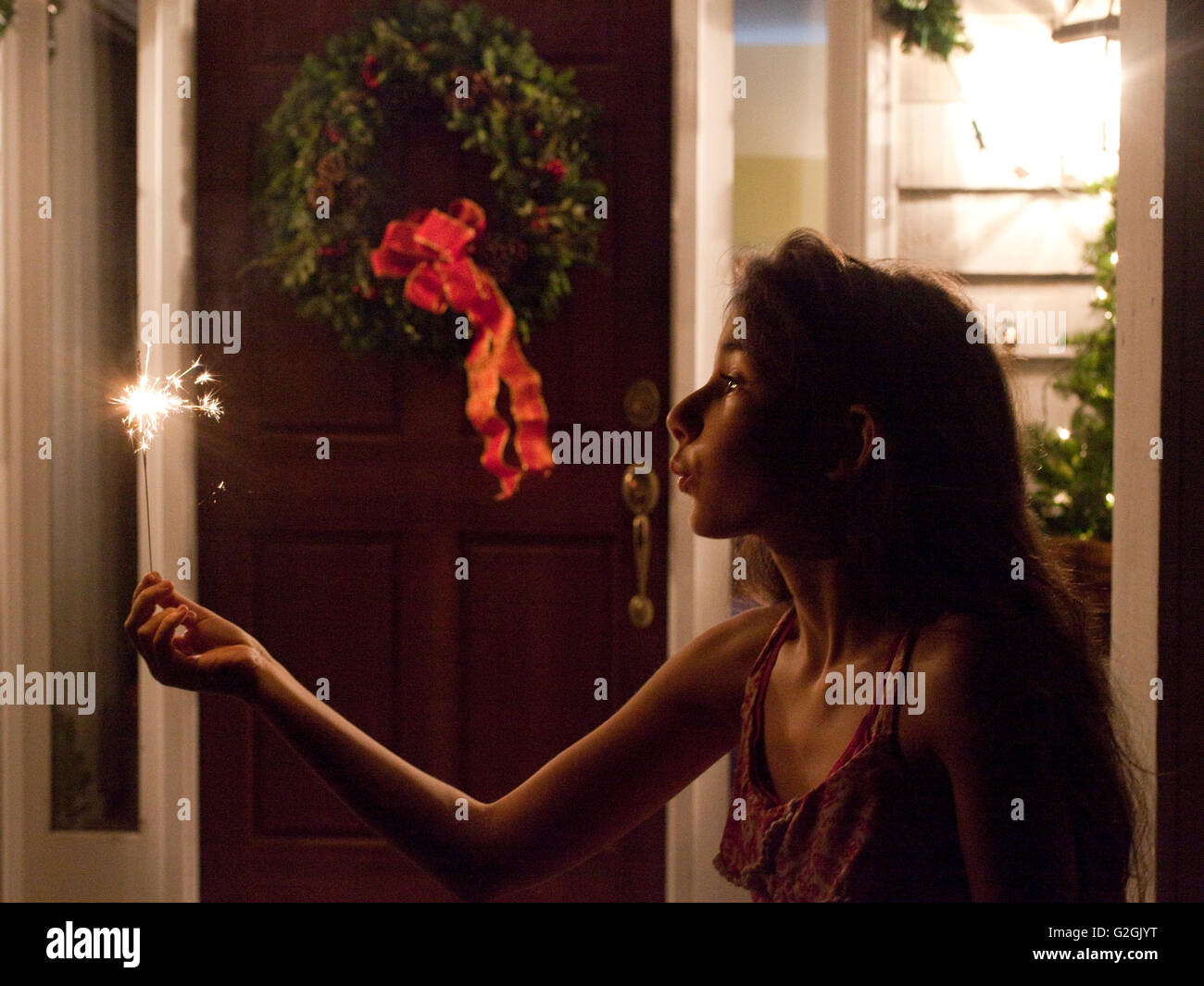Girl with sparkler la nuit en face de la maison Banque D'Images