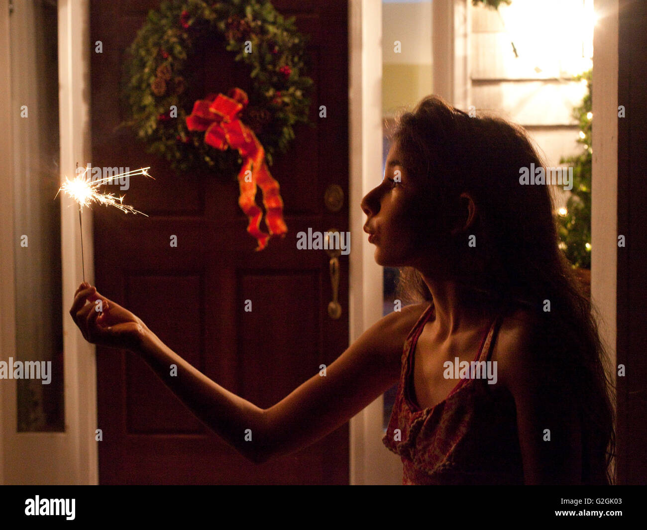 Girl with sparkler la nuit en face de la maison Banque D'Images