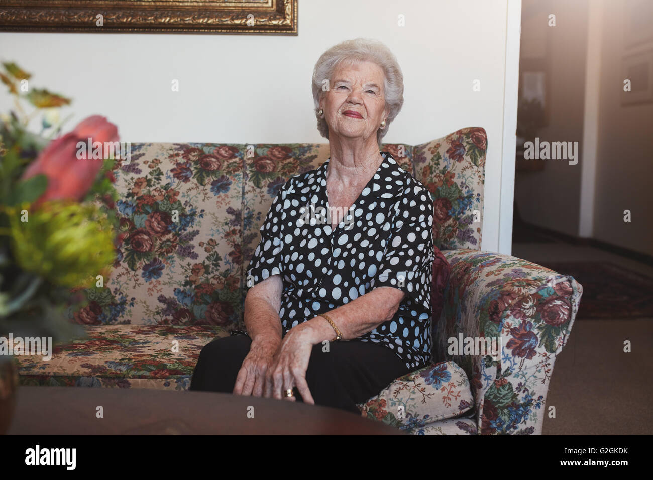 Portrait of happy vieille femme assise sur un canapé. Senior woman relaxing at home de la vieillesse. Banque D'Images