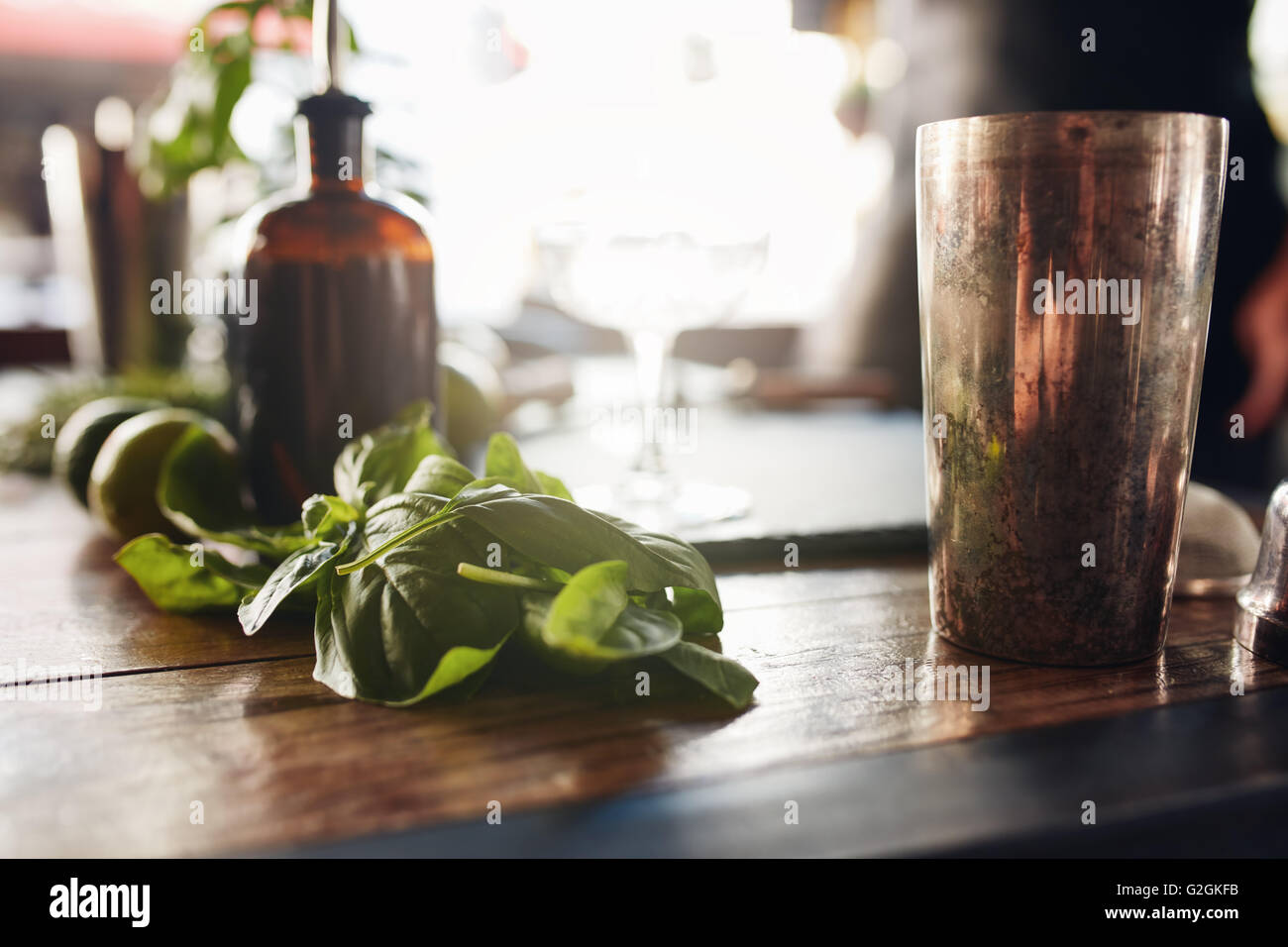 Photo de gros plan avec feuilles de basilic shaker et d'autres ingrédients sur table au bar. Banque D'Images