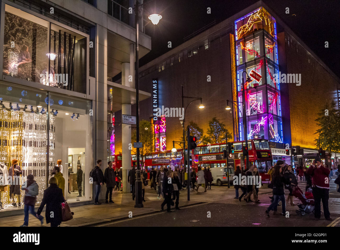 Les gens qui marchaient ont passé le grand magasin Debenhams sur Oxford St à Noël qui a été décoré avec des lumières de Noël, Londres, Royaume-Uni Banque D'Images
