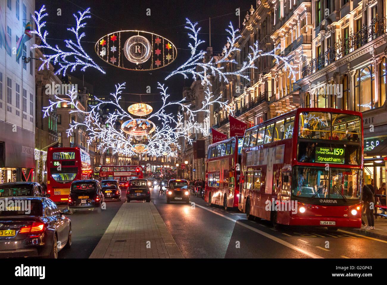 Bus et circulation sur Regent St à Noël, avec les Regent St Christmas Lights suspendues de l'autre côté de la rue dans le West End de Londres à Noël, Londres Banque D'Images