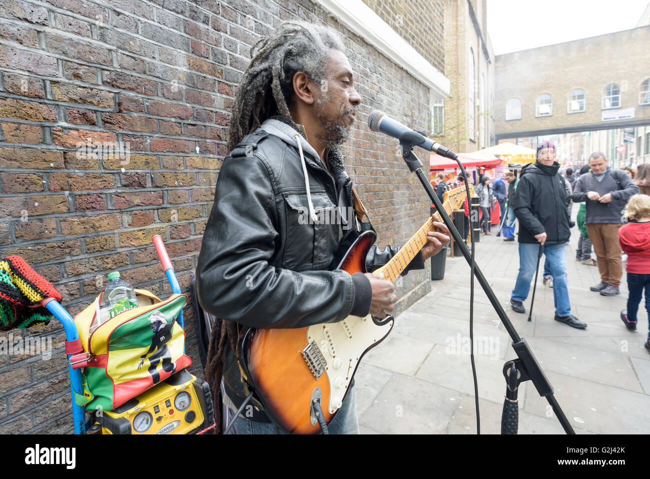Un musicien ambulant de la rue de l'argent avec joue d'une guitare électrique pour les dons sur Brick Lane à Londres pendant le 1er mai Jour férié Banque D'Images