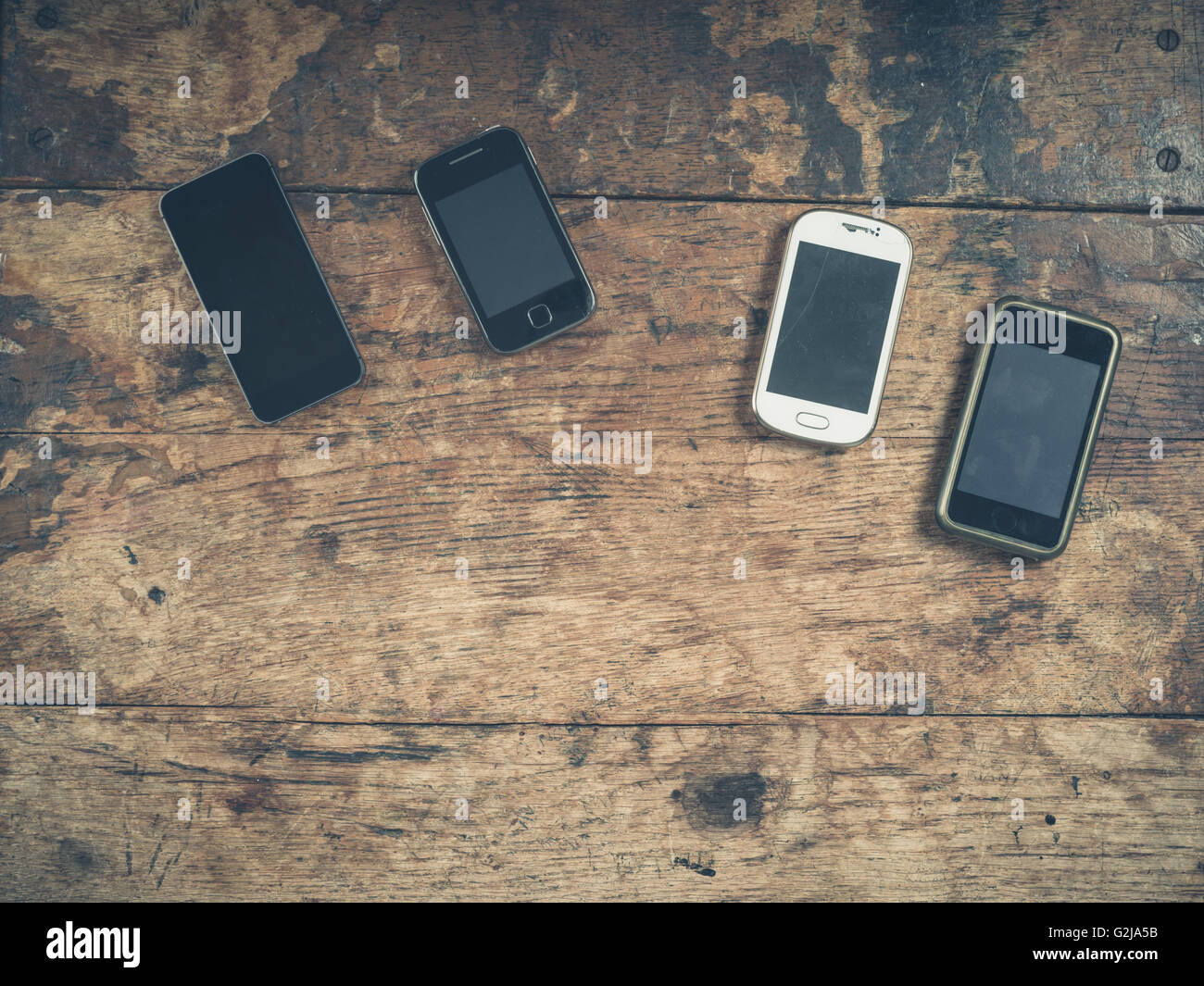 Une sélection de téléphones intelligents sur une table en bois Banque D'Images