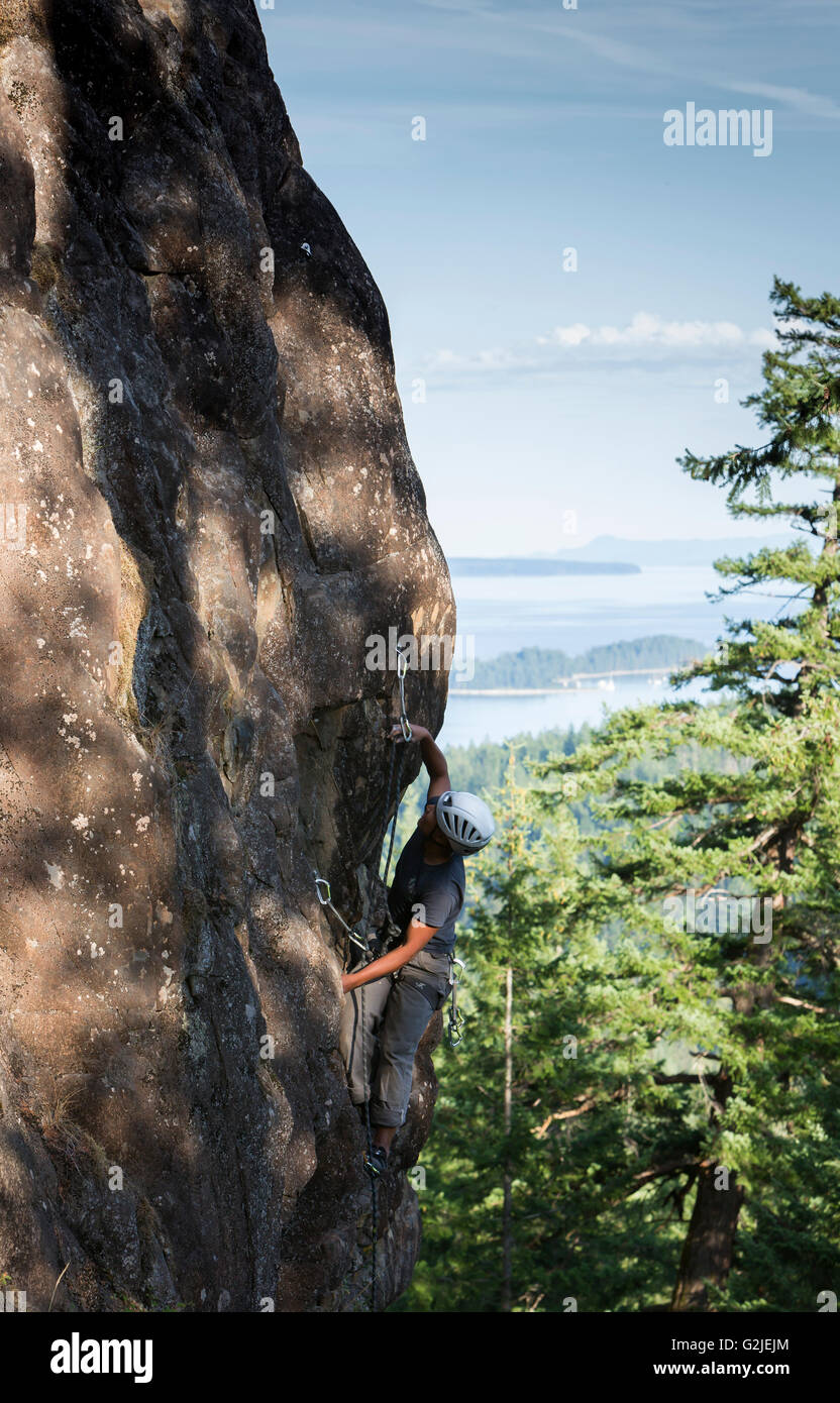 Un male rock climber dirige une voie sur un béton alors que l'escalade de l'île Quadra Quadra Island îles du nord du Golfe Banque D'Images
