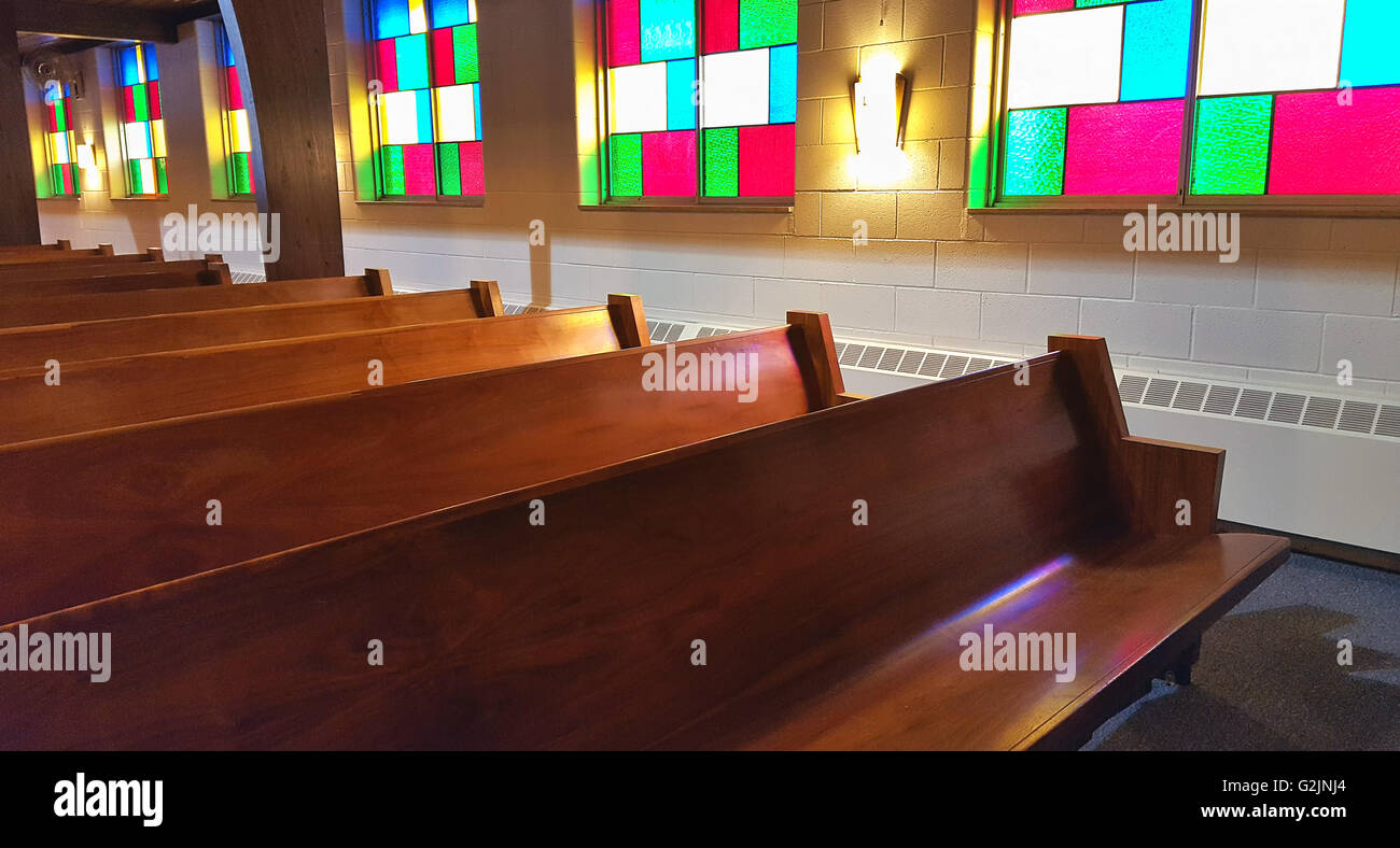 Bancs d'église en bois avec verre teinté de réflexion de la lumière. Banque D'Images