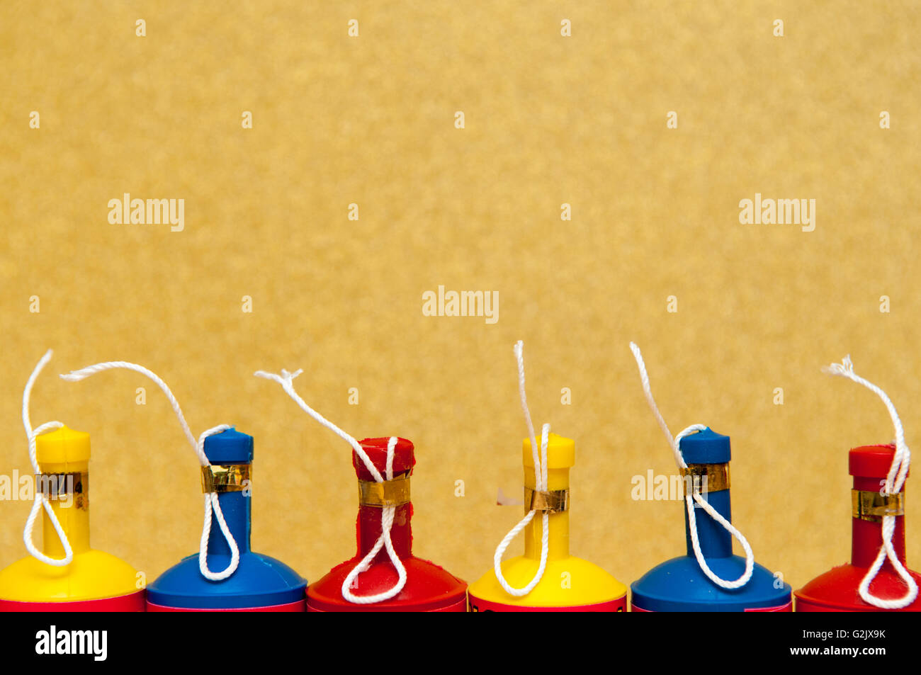 Poppers parti colorés disposés en une rangée sur un arrière-plan lumineux Banque D'Images
