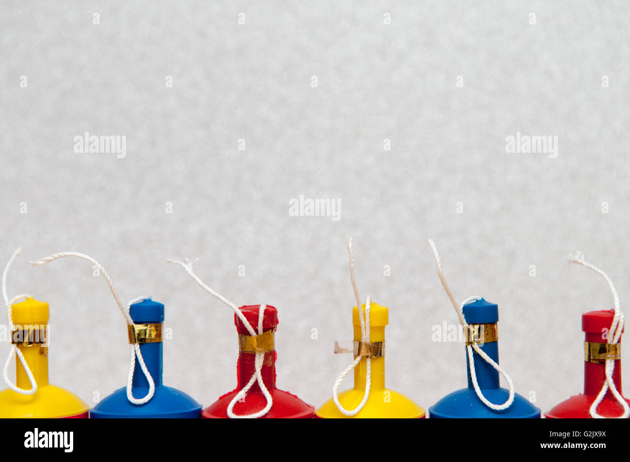 Poppers parti colorés disposés en une rangée sur un arrière-plan lumineux Banque D'Images