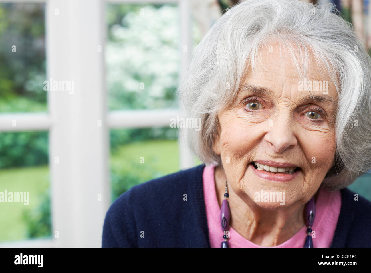 Head and shoulders Portrait Of Smiling Senior Woman at Home Banque D'Images
