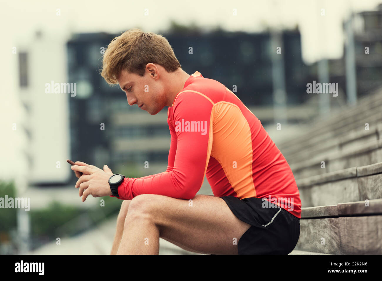 Sportive urbaine app contrôle sport performance sur son téléphone mobile. Arrière-plan de la ville Banque D'Images