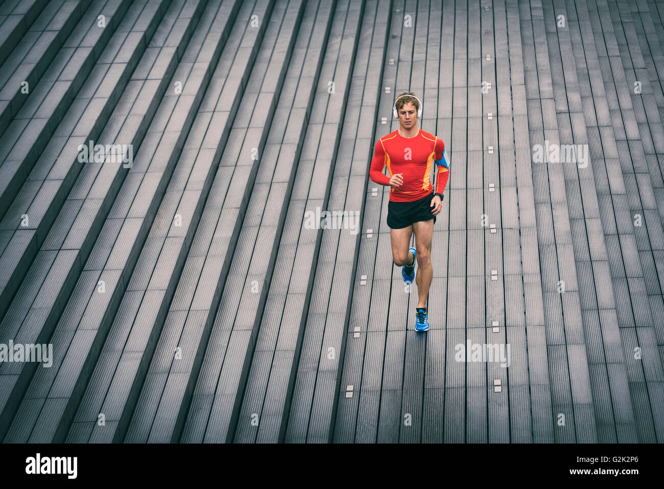 L'athlète exécute le jogging à l'extérieur d'écouter de la musique sur téléphone cellulaire. Le sport à l'extérieur Banque D'Images