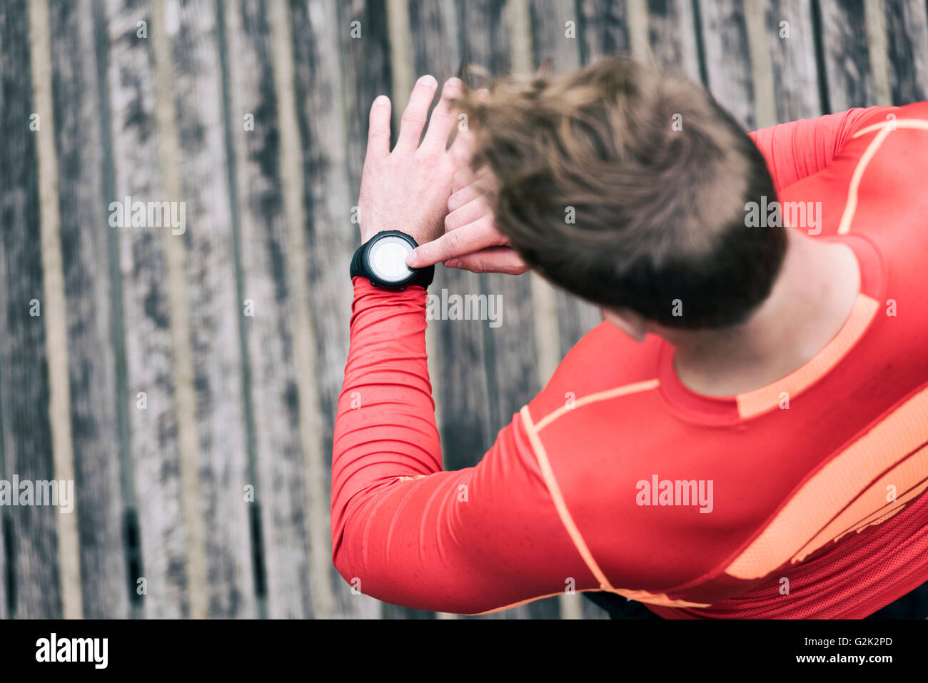 Homme courant à la sportwatch. Jogging homme à l'aide de smart watch à l'extérieur Banque D'Images