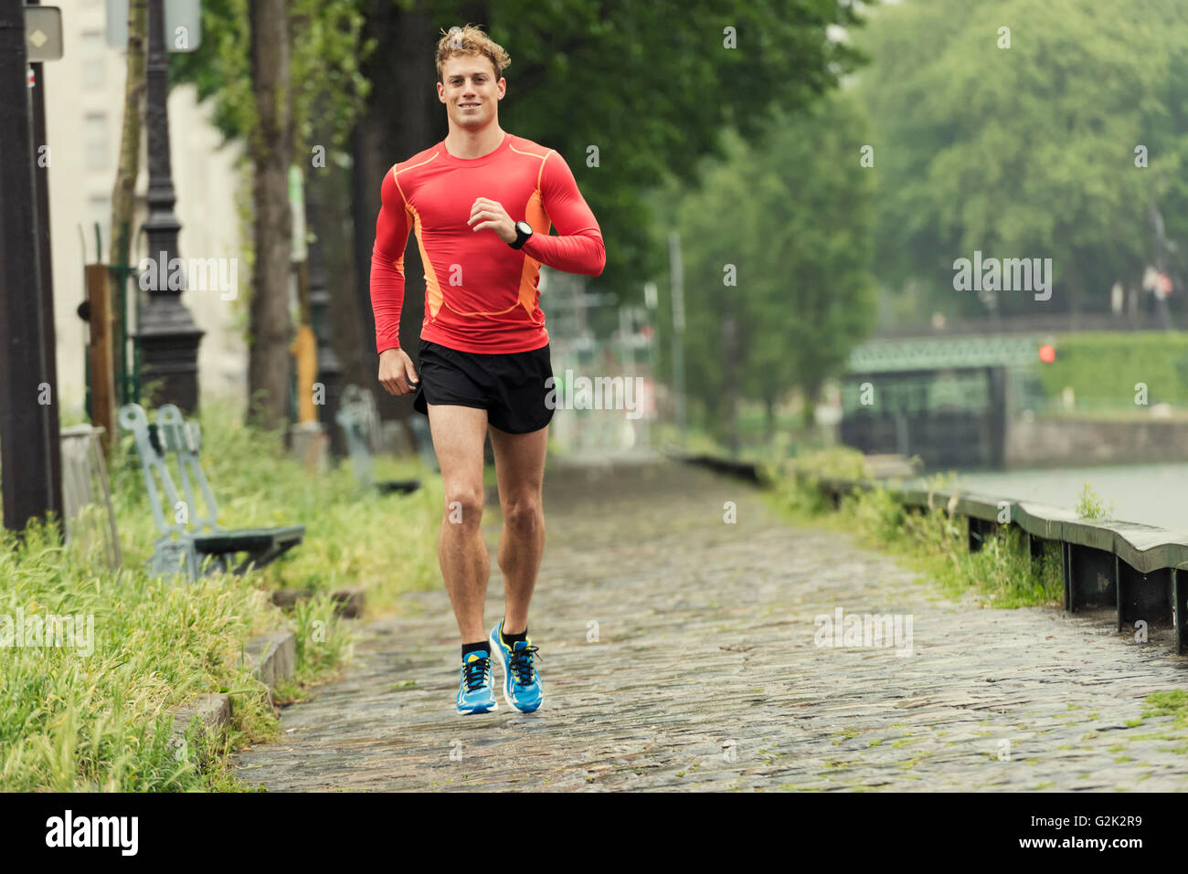 Jeune homme en train de courir dans la ville. Portrait souriant jogger homme dans son 20s Banque D'Images