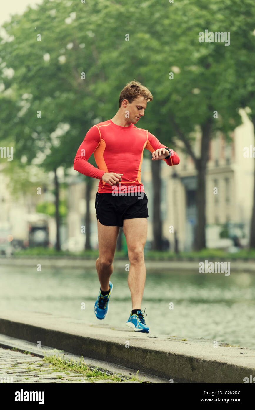 Running Man en regardant son moniteur de fréquence cardiaque smart sports watch lors de l'entraînement de la formation Banque D'Images