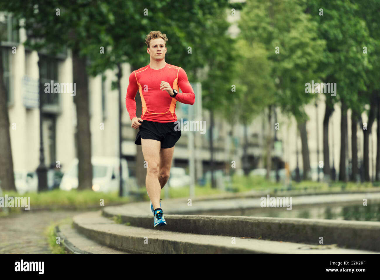 Jeune homme en train de courir dans la ville. Portrait souriant jogger homme dans son 20s Banque D'Images