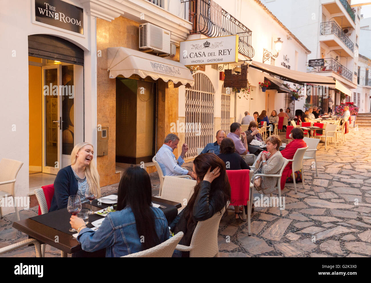 Des gens assis de manger dans un restaurant le soir, Estepona, Espagne Andalousie Banque D'Images