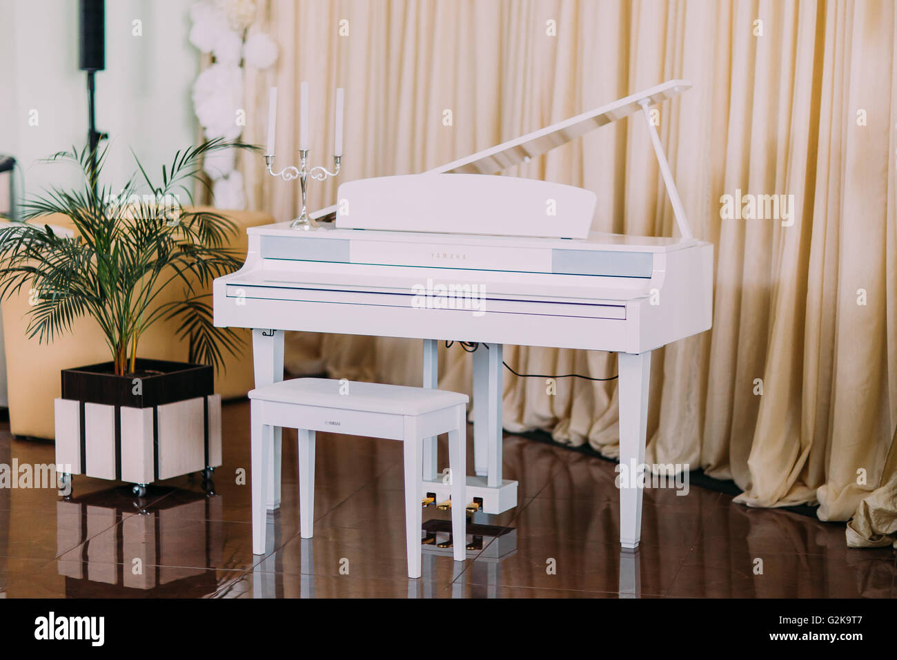 Grand piano blanc moderne de luxe en salle avec pêche pâle sur fond de  rideau Photo Stock - Alamy