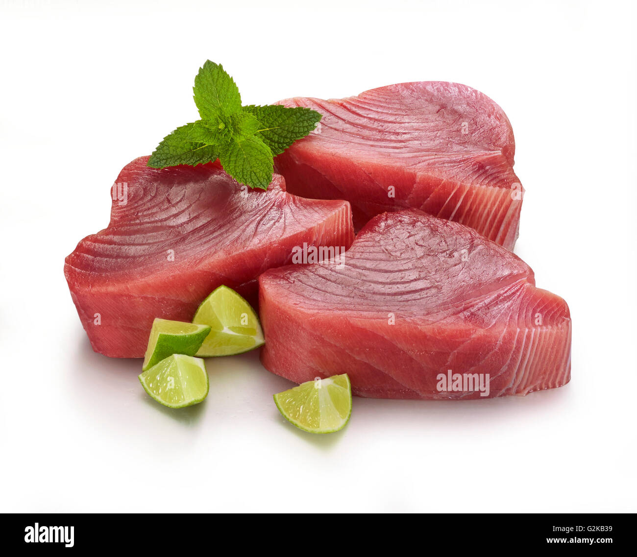 Filet de thon (Thunnus sp.), menthe (Mentha) et de lime (Citrus aurantifolia), fond blanc Banque D'Images